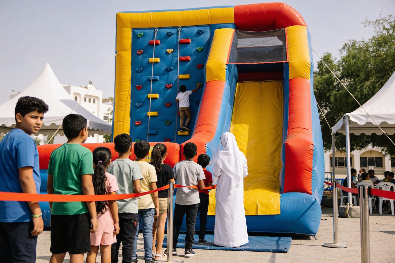 Inflatable climbing wall with slide at a school event in Dubai