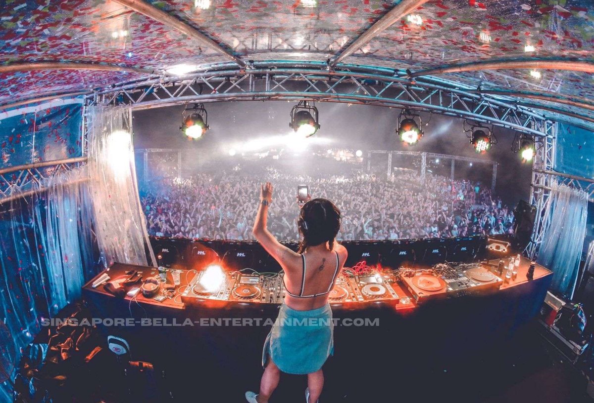 DJ playing to a large crowd from the stage DJ playing to a large crowd from the stage