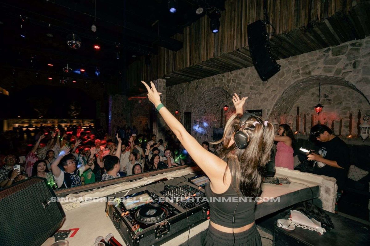 Female DJ hyping a crowd at an event Female DJ hyping a crowd at an event