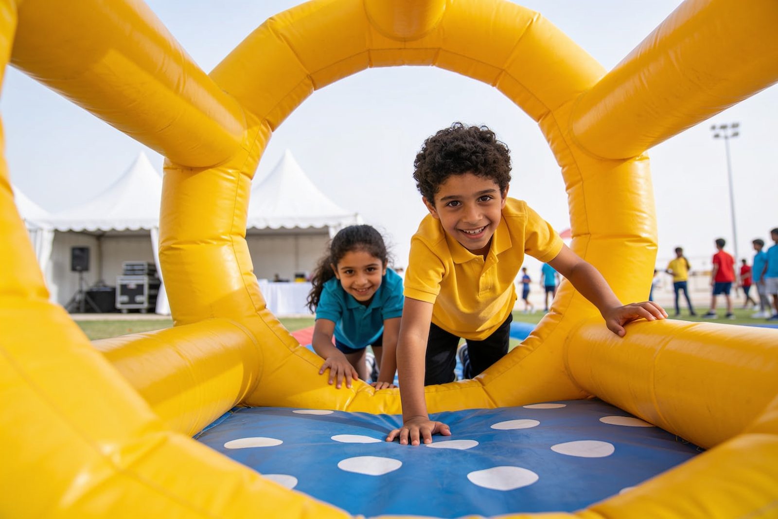 Kids on an inflatable obstacle course at a school event in Dubai