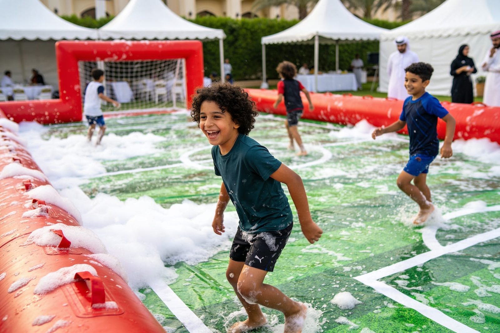 Kids playing on an inflatable slippery football field in Dubai