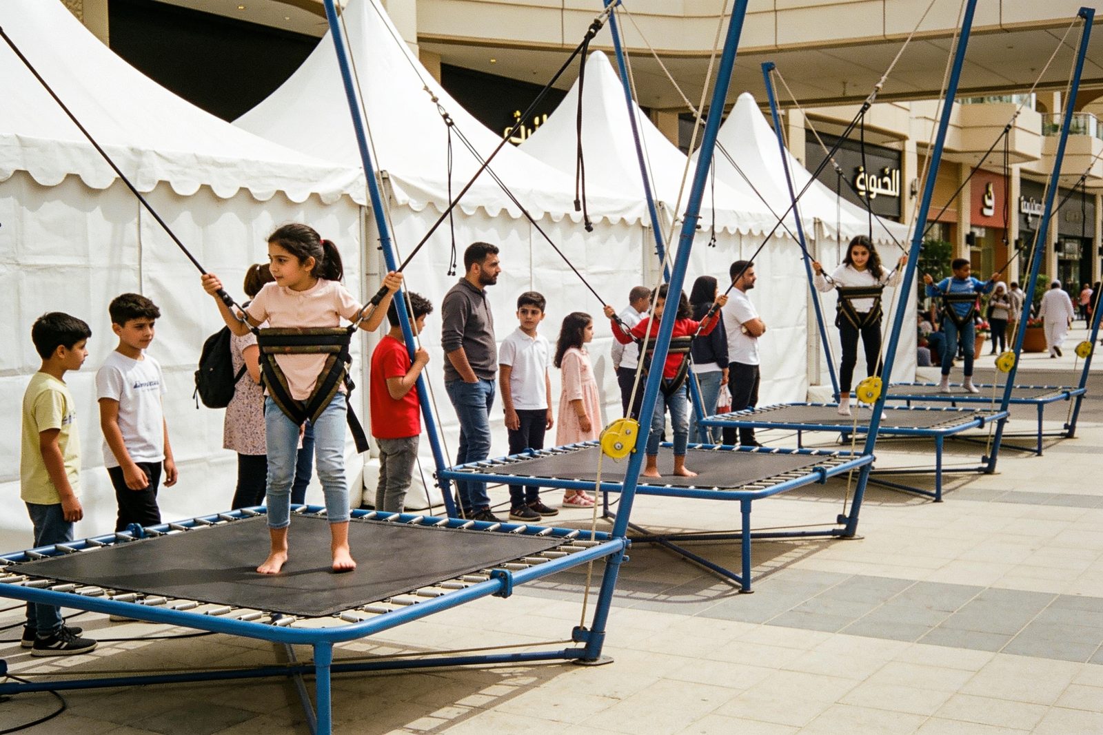 Kids queueing for bungee trampolines at a Dubai event