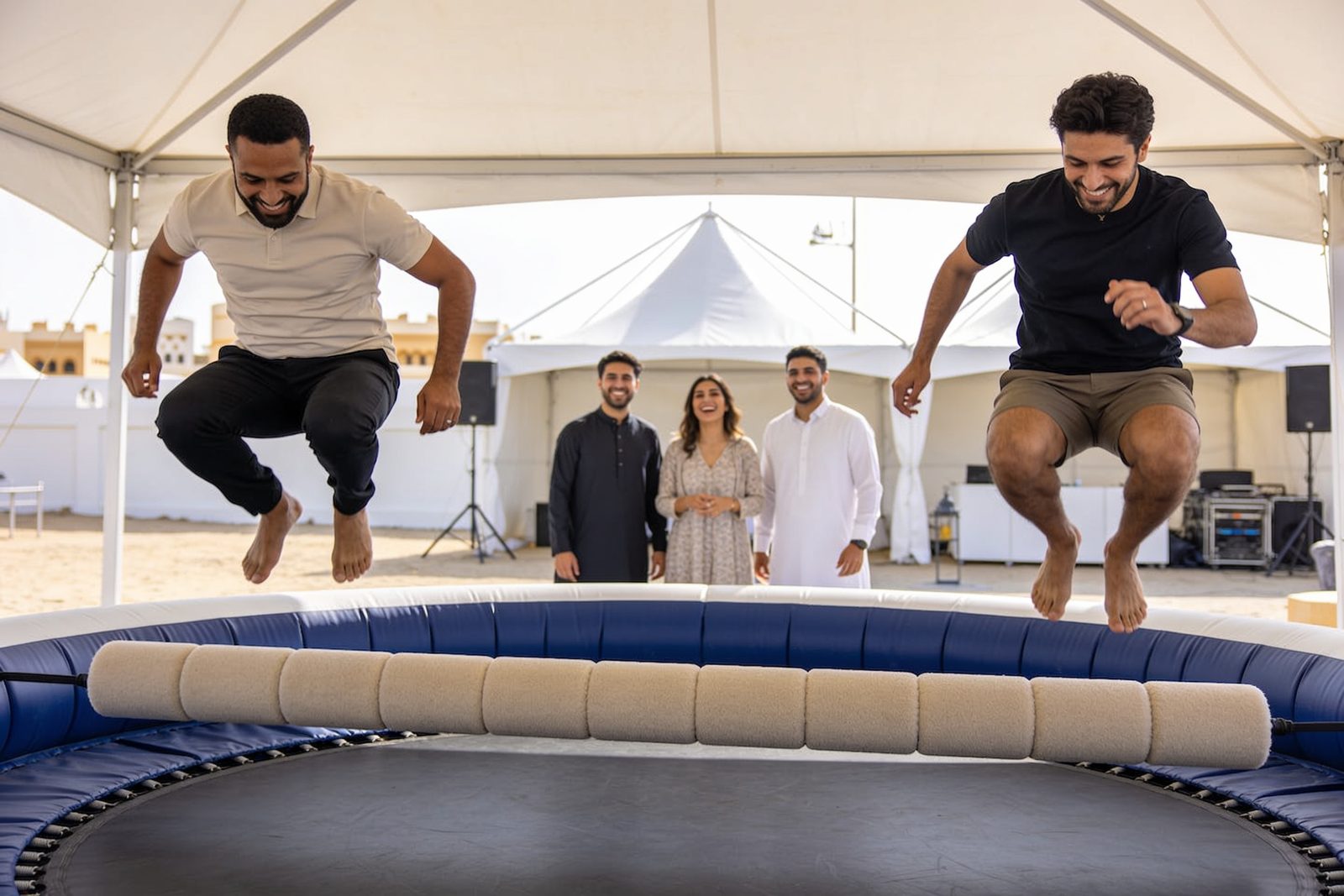 Players jumping a padded sweeper bar in Dubai
